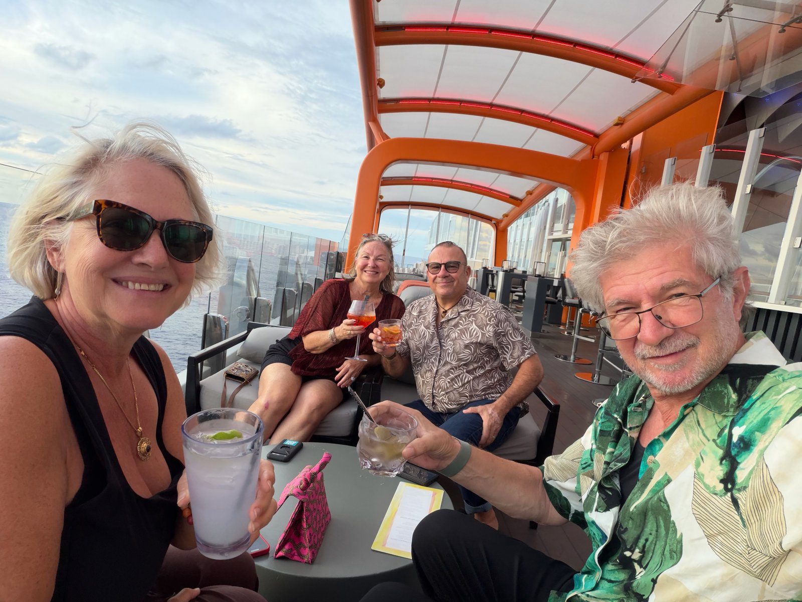 Alex, Leigh-Ann, and friends raising drinks together on the ship's deck