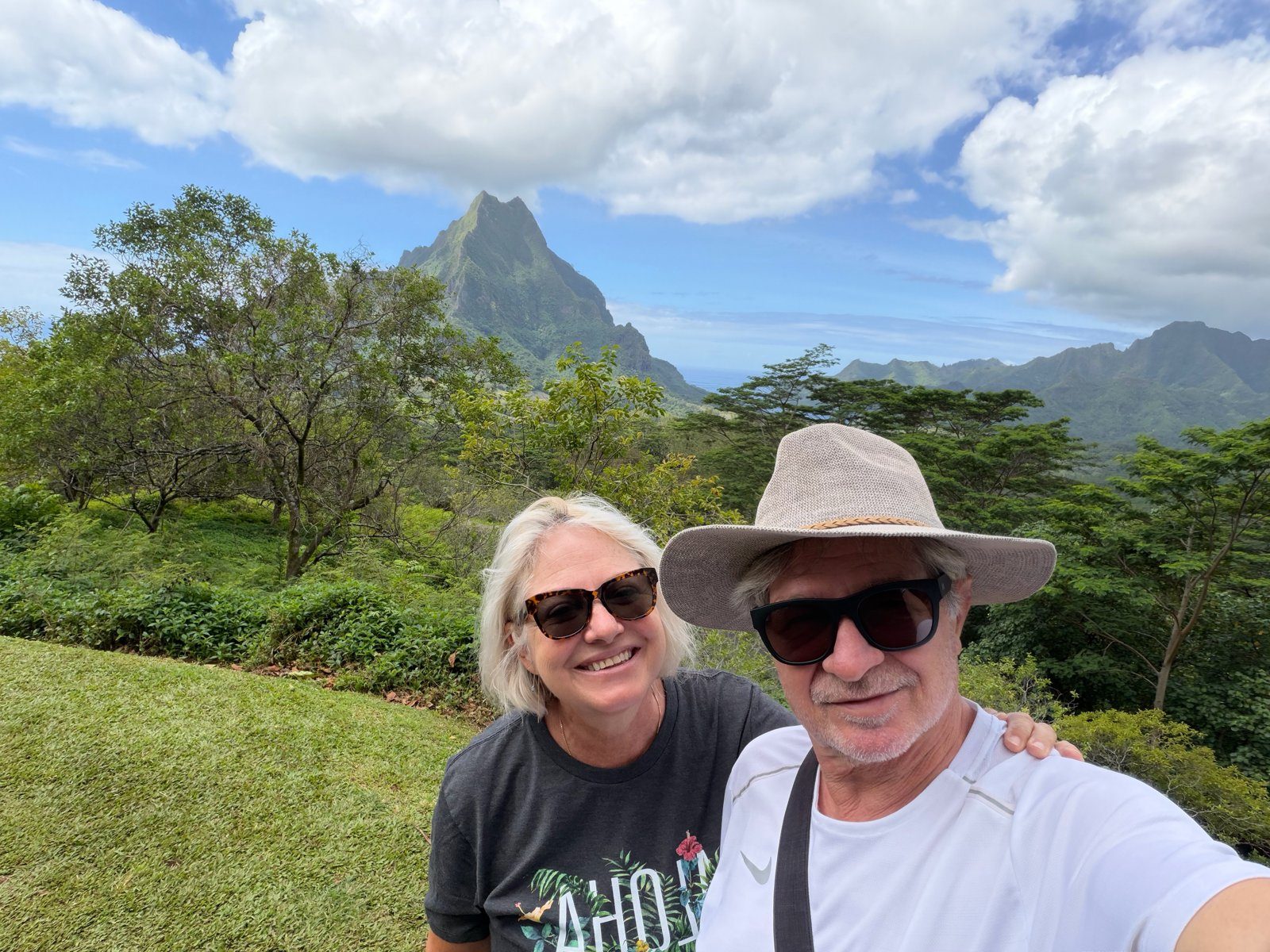 Alex and Leigh-Ann taking a selfie with jagged green peaks behind them